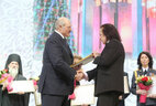 Александр Лукашенко вручает награду члену Белорусского союза художников Юрию Руденко