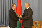 Александр Лукашенко вручает удостоверение Павлу Каллауру