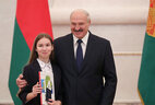 Belarus President Aleksandr Lukashenko presents a passport to student of Bobruisk gymnasium No. 1 Polina Gavrik