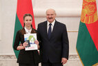 Belarus President Aleksandr Lukashenko presents a passport to student of Gantsevichi secondary school No. 1 Polina Golubovich