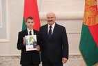 Belarus President Aleksandr Lukashenko presents a passport to student of Baranovichi secondary school No. 9 Matvei Goldberg