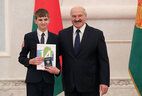 Belarus President Aleksandr Lukashenko presents a passport to student of Mogilev secondary school No. 18 Vladimir Grabarev