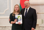 Belarus President Aleksandr Lukashenko presents a passport to student of Krugloye secondary school No. 2 Ruslana Kachalova