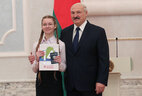 Belarus President Aleksandr Lukashenko presents a passport to student of Vitebsk secondary school No. 12 Yelizaveta Leonova