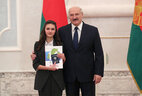 Belarus President Aleksandr Lukashenko presents a passport to student of Soligorsk secondary school No. 11 Alina Dokuchayeva