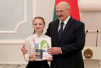 Belarus President Aleksandr Lukashenko presents a passport to student of Minsk secondary school No. 215 Alena Mataras