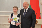 Belarus President Aleksandr Lukashenko presents a passport to student of Oshmyany gymnasium No. 3 Violetta Zagorskaya