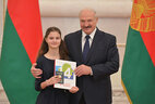 Belarus President Aleksandr Lukashenko presents a passport to student of Slonim secondary school No. 5 Yekaterina Kovalevskaya
