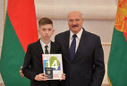 Belarus President Aleksandr Lukashenko presents a passport to student of Minsk gymnasium No. 5 Maksim Lobosov