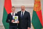 Belarus President Aleksandr Lukashenko presents a passport to student of Gomel secondary school No. 67 Yevgeny Prokhorenko