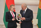 Belarus President Aleksandr Lukashenko presents a passport to student of Vitebsk gymnasium No. 2 Anastasiya Morozova