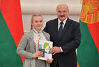 Belarus President Aleksandr Lukashenko presents a passport to student of Vitebsk gymnasium No. 7 Mariya Yurkova