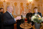 Аляксандр Лукашэнка з сынам Мікалаем і Мітрапалітам Філарэтам запальваюць свечкі