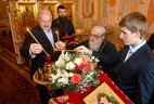 Аляксандр Лукашэнка з сынам Мікалаем і Мітрапалітам Філарэтам запальваюць свечкі