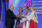 The festival organizers give Alexander Lukashenko an amulet belt, the most valuable gift to a man for Slavonic peoples