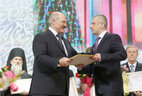 Alexander Lukashenko presents the award to head of the ATN cultural news department Mikhail Revutsky