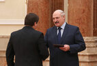 Александр Лукашенко вручает диплом председателю Постоянной комиссии Палаты представителей по образованию, культуре и науке Игорю Марзалюку