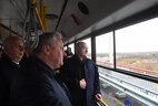 Alexander Lukashenko and executives ride a bus across the bridge as they open the road to traffic