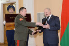 Belarusian Defense Minister Andrei Ravkov presents the Kalashnikov assault rifle in a special case to Belarus President Alexander Lukashenko