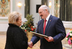 The President gives an official letter of thanks to director of the Mogilev social service center Tatyana Rozhkova