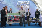 Alexander Lukashenko receives a group photo of the prominent athletes, the participants of the festival, with their autographs