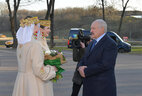 Главу государства по традиции встречали с букетом цветом две девушки, облаченные в верхнюю теплую одежду в национальном стиле