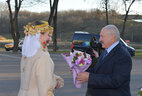 Главу государства по традиции встречали с букетом цветом две девушки, облаченные в верхнюю теплую одежду в национальном стиле