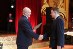 Sergei Aderikho, BelTA's deputy director general for ideological work, receives a letter of commendation from the Belarusian President