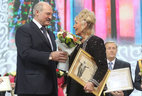 Alexander Lukashenko presents the award to member of the Belarusian Union of Painters Tatyana Rudenko