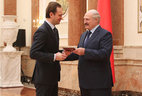 Александр Лукашенко вручает диплом ректору Белорусского государственного университета физической культуры Сергею Репкину