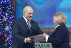 Александр Лукашенко вручает награду художественному руководителю Валентине Кондратьевой.