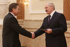 Alexander Lukashenko presents the diploma of the NASB academician to academic secretary of the Department for Biological Sciences Mikhail Nikiforov