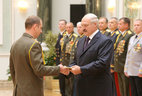 Graduate of the command and staff department of the Military Academy of the Republic of Belarus Lieutenant Colonel Maxim Khvirisyuk receives an official letter of thanks from the President