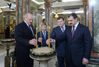 Alexander Lukashenko lights and places a commemorative candle in the center of the crypt with a holy fire lamp