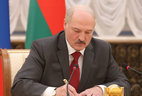 Alexander Lukashenko signs a number of documents after the session of the Union State Supreme State Council