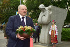 A ceremony to place a symbolic flower basket at the memorial to the victims of Holodomor