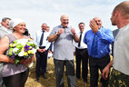 Alexander Lukashenko talks to harvester operators Irina Khoruzhaya and Nikolai Khoruzhy