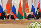 Belarus President Alexander Lukashenko and Russia President Vladimir Putin sign documents after the summit