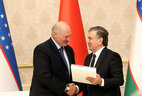 Uzbekistan President Shavkat Mirziyoyev gives Belarus President Alexander Lukashenko the first copy of Yakub Kolas’ poems in the Uzbek language as a gift