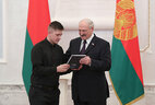 Aleksandr Lukashenko presents a passport to student of the Glusha college Maksim Parkhimchik