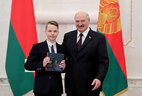 Aleksandr Lukashenko presents a passport to student of Lida secondary school No. 1 Pavel Poznyak