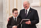 Aleksandr Lukashenko presents a passport to student of Baranovichi secondary school No. 3 Nikita Deyko